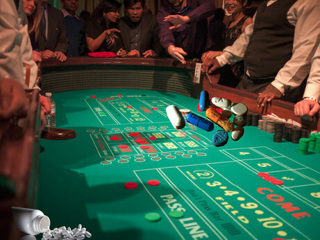 A craps table surrounded by excited gamblers; amid the casino chips are various pharma tablets, some spilling out of a pill bottle.

Image:
Chris Martin (modified)
https://www.flickr.com/photos/cjmartin/11331819423

CC BY 2.0:
https://creativecommons.org/licenses/by/2.0/


Christine Dela Cerna (modified)
https://commons.wikimedia.org/wiki/File:Various_pills.JPG

CC BY-SA 3.0:
https://creativecommons.org/licenses/by-sa/3.0/deed.en