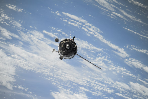 Fotografía de un satélite orbitando la Tierra, con la atmósfera de fondo.