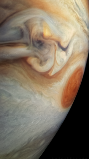 In this image the Great Red Spot of Jupiter: a huge red anticyclonic storm surrounded by the typical swirling white stripes (called zones) and orange stripes (called belts) that characterize this gas giant planet.