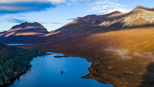 Flying above the loch, hills to the right and in the distance.