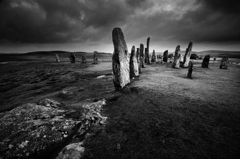 Rows of tall standing stones under a heavy sky.
