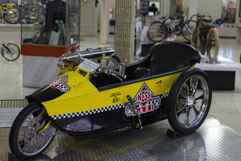 There are other Arlen Ness bikes throughout the museum with his wonderful colorful airbrushed fantasy artwork or curvy patterns, but what really stands out about this one is his sense of 4 color discipline- just a glossy black, vivid yellow, red accents and the silvery chrome skeleton adorn this trike.  It makes every shape and detail stand out boldly, whether it's the shape of the bike, the patterns that run across it, or the centerpiece artwork along the side and front.