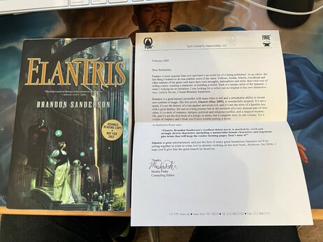 An Advanced Reading Copy of "Elantris" by Brandon Sanderson. To its right is a letter from the book's editor, introducing the book (and Brandon) to book sellers.