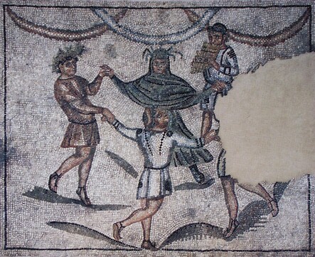 The mosaic shows four Genii holding hands and dancing in a circle. Each of the Genii represents a season: Autumn, wearing a wreath of grapes, is at the bottom of the mosaic; Winter, wearing a hooded cloak, is at the top, and Spring is on the left, wearing  a wreath of blossoms. The part of the mosaic that shows Summer is broken off. The dancing group is accompanied by a man playing a panflute.