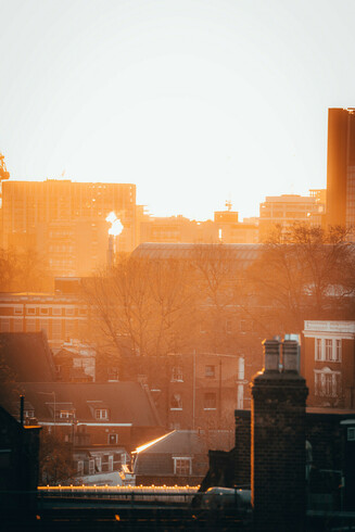 The sun plays on the chimneys and roofs of lambeth.