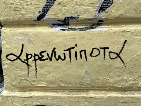 Handwritten on a wall, the pun described in the text
