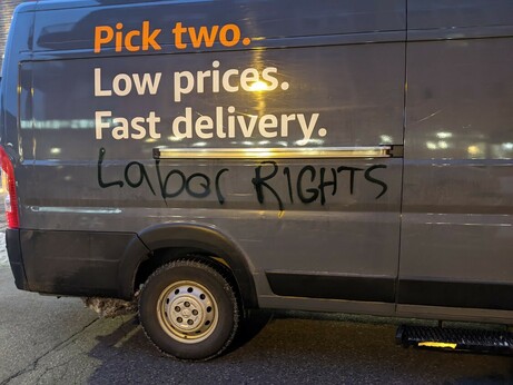 Amazon van with graffiti that reads, "Labor rights" below the amazon slogan of "Pick two. Low prices. Free delivery."