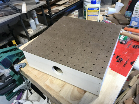 Upgraded downdraft table made from pegboard and aspen, with a hole cut in the side to fit a vacuum hose (still surrounded by junk...)