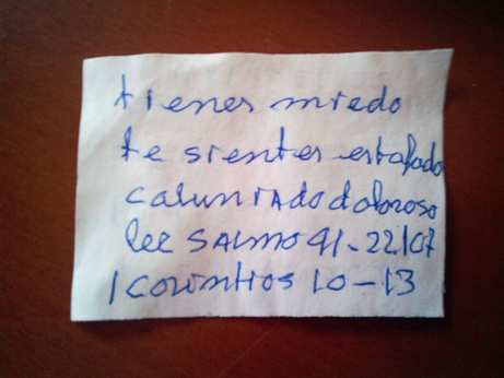 Trozo pequeño de papel que pone lo siguiente escrito a mano con una caligrafía rudimentaria:

tienes miedo te sientes enfadad calumniado doloroso lee salmo 91 [ininteligible]
1 corintios 10-13