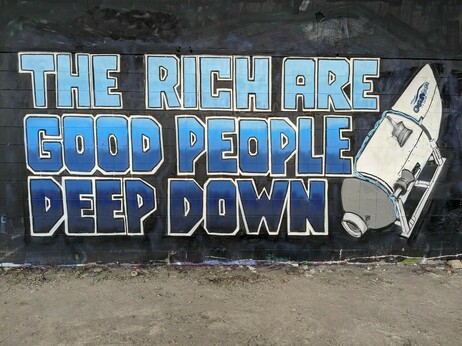 Mural on a black wall featuring the titan submersible and the words "The rich are good people deep down" in blue