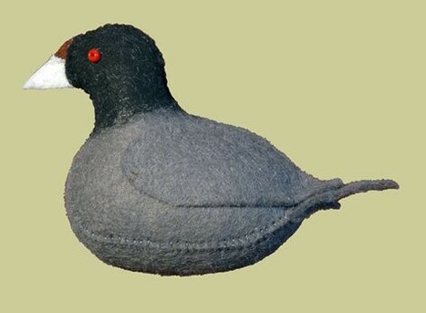 Craft bird made out of felt in the shape of the waterbird known as a coot: overall gray body, blackish head, white bill and red eye.