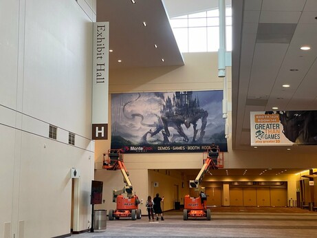The Monte Cook Games Room 132 sign being put up at Gen Con, 2023