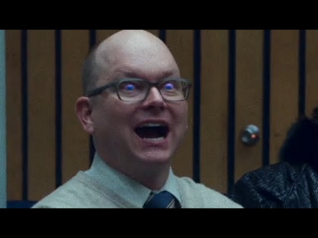 Photo of Colin Robinson, Energy Vampire from "What We Do In The Shadows", in the middle of feeding. His eyes are glowing, and he's obviously pleased.