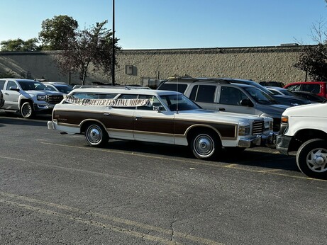 Wood paneled 70s station wagon with a Vintage Computer Festival Midwest banner on it