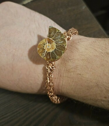 Viking knit bracelet with an ammonite crudely stitched in