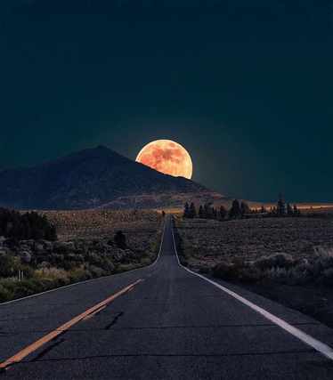 Moonrise over the mountain on a desert highway. 

Not my photo.