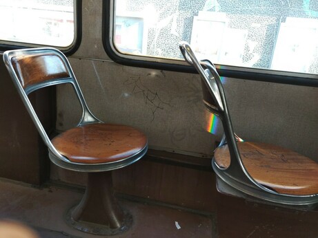 Zwei der rundlich geformten Holzsitze im Tramwagen.
