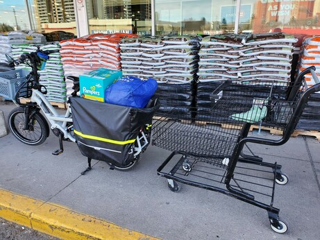 The grocery cart is empty and all the groceries are in the back panniers of my bike
