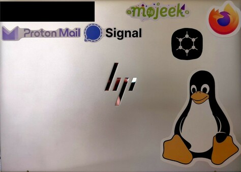Laptop lid with stickers of Mojeek, FireFox, Proton Mail, Signal, GrapheneOS, and Linux. One sticker has been hidden.