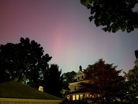 Picture of a night sky with exaggerated colors of pink and blue, due to the northern lights phenomenon.
