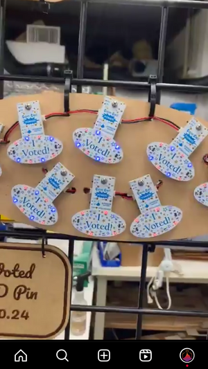 I Voted pins lit up and displayed with Coin Cell power boards that emulate CR2032 batteries