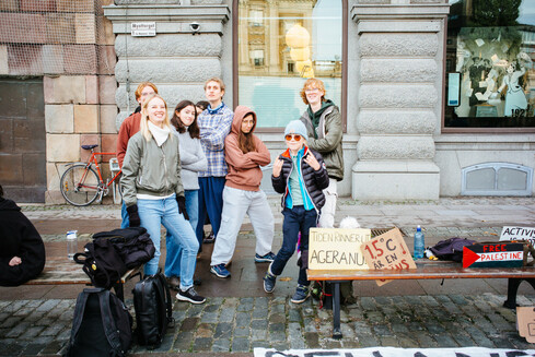 A group of young protesters posting beside placards.
