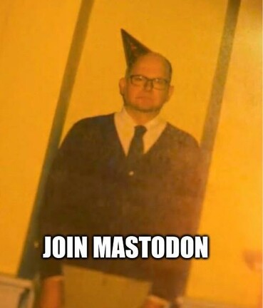Colin Robinson, de Lo que hacemos en las sombras, con un gorro de fiesta y pose de oficinista aburrido frente a un fondo amarillo hospital. Superpuesta la inscripción "join mastodon"
