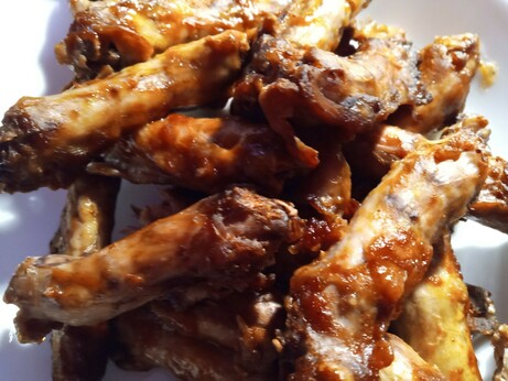 A large bowl of Baked chicken parts, the necks only (about 20 necks), with BBQ sauce on them
