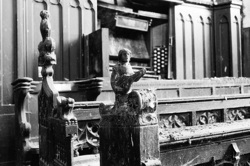 carved wood pews with a figure of a man playing a lute