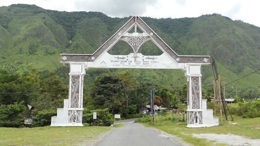 Another ornamental gateway showing curls and other symbols similar to designs on marae gateways and whare whakairo in Aotearoa New Zealand. This one even has the red, white and black colour scheme used by Māori.
