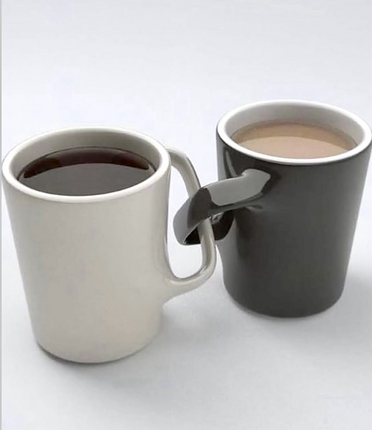 Two cups in white and gray where the handles are hooked together, which would mean you’d spill if trying to drink.