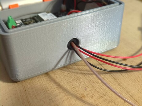 A photo of the same case showing the wires protruding from the grommet.