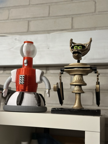 3D printed Tom Servo and Crow T Robot on top of a bookcase.