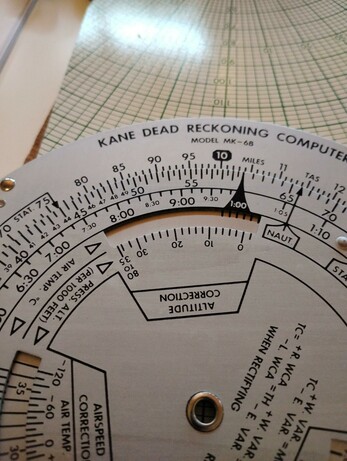 Upper curve of a Kane Dead Reckoning Computer circular slide rule. It is made of aluminum with black numbers and tick marks.