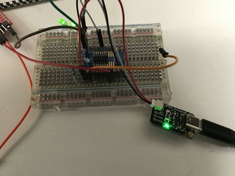 Breadboard with an ATTiny414 chip, connected to an Adafruit UDPI Friend programmer.