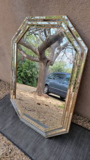 Mirror reflecting an oak tree and a car, with the oak tree nicely framed by the mirror.