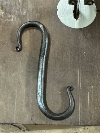 A simple mild-steel S-Hook, forged from a length of 10mm reo (rebar). From the apex of each curve to the other is 15cm. and the hook opening space is 3cm. the hook depth is approximately 3.5cm. 
It has been wire-brushed, then hot-oil finished.