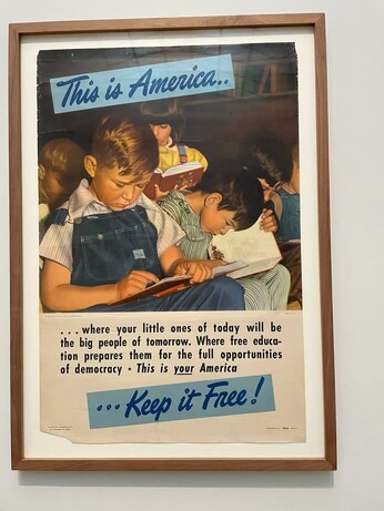 A photo of an old 50s/60s American poster showing children learning, with the slogan " This is America... where your little ones of today will be the big people of tomorrow. Where free education prepares them for the full opportunities of democracy. This is your America, keep it free!"
