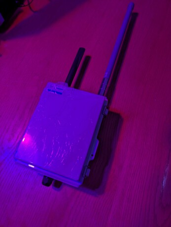 A weather proof box with two 915MHz antennas is lit in bisexual lighting.