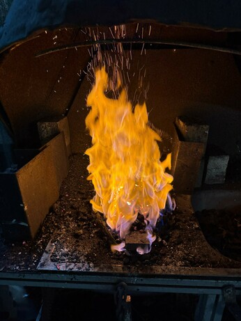 The forge in full swing. Flames about 30cm high with sparks at the top.