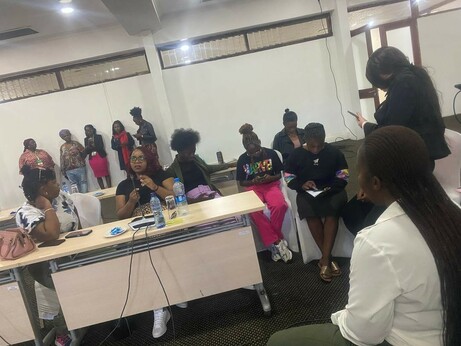 Photo of a group of black women gathering in a conference room in Lusaka, Zambia. There is a group of people standing in the back, as well as several sitting in front of tables, as well as and on the side.  The picture was shot while onboarding with Delta Chat Android took place, and people in the picture consented to publishing.
