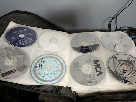 A photo of a book filled to the brim with music CDs.