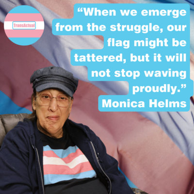 “When we emerge from the struggle, our flag might be tattered, but it will not stop waving proudly.” Monica Helms Photo: Monica Helms, a woman with long hair wearing a cap and glasses. In the background of the image is a big trans flag