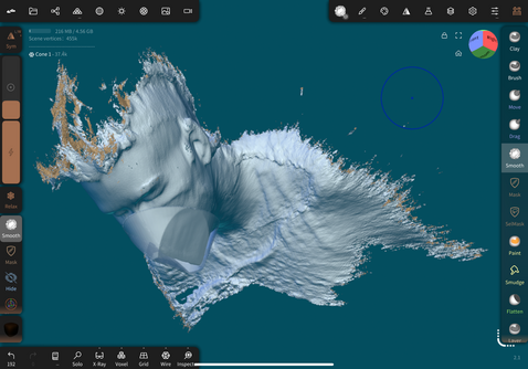 A screenshot from Nomad Sculpt with Alex looking windblown, due to the particles shooting off the edges of a 3D scan of her face and upper torso. A translucent mask shape is being formed over the actual mask in the model.