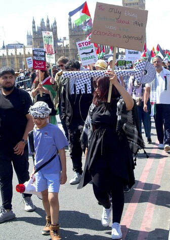 woman and son carrying a giant key of return wrapped in keffieh
