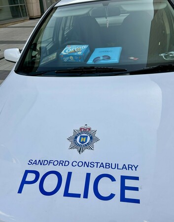 White Vauxhall Astra marked as a "Sandford Constabulary Police" car. Items from the film on the dashboard.