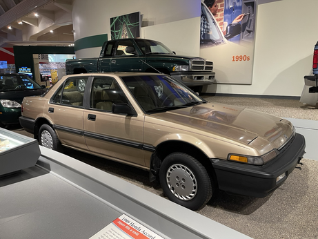 This is a photo of the Honda Accord. It’s a gold brown color with a very thick black bumper.