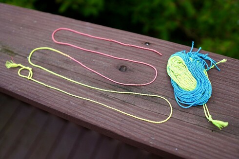 A long string from Foxtail Strings that is laid out so you can see how it fades from yellow threads to pink threads.  There is also a stack blue to yellow threads too.