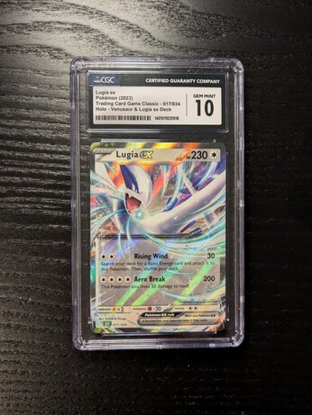 The image shows a graded Lugia V Pokémon card.

It is encased in a protective slab with a label at the top indicating a perfect grade of "10."

The card itself features Lugia, a legendary Pokémon, and has a holographic or foil effect. 

The slab is placed on a dark, textured surface.
