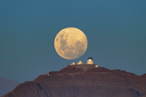 Another night of observing begins at the U.S. National Science Foundation Cerro Tololo International Observatory (CTIO) in the Chilean Andes, a Program of NSF NOIRLab, as the Moon sets below the horizon. The Moon appears massive and with a mysterious yellowish glow as it retreats behind the SMARTS–GSU 0.9-meter Telescope on the left, the SMARTS–GSU 1.5-meter Telescope in the center, and the Víctor M. Blanco 4-meter Telescope on the right.